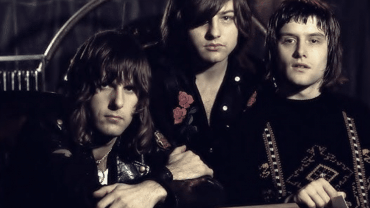 Emerson, Lake & Palmer posing in a studio setting, featuring Keith Emerson, Greg Lake, and Carl Palmer.