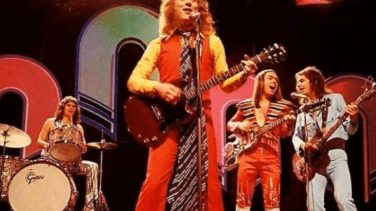 Glam rock band Slade performing on stage in vibrant outfits during the 1970s, showcasing their energetic and iconic style.