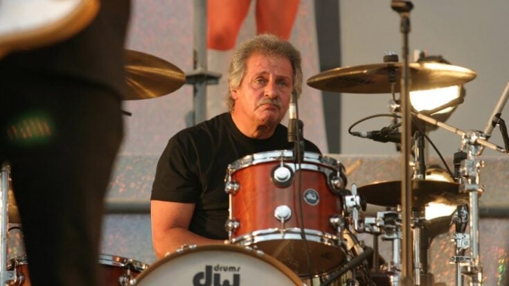 Pete Best sitting in his drum set while performing
