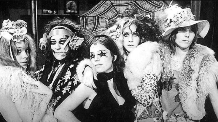 Groupies posing for a picture wearing elegant dresses and outfits