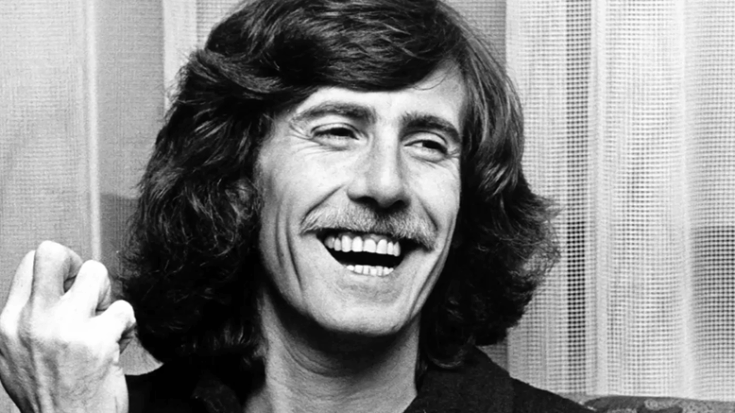 Graham Nash smiling in candid moment during 1970s, showcasing iconic long hair and mustache