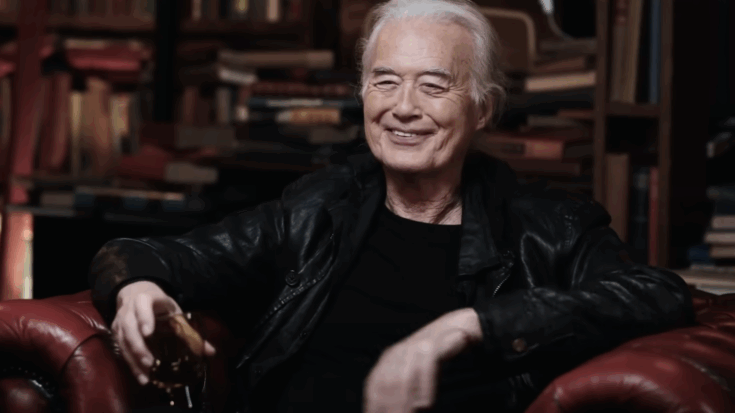 Jimmy Page smiling wearing a leather jacket