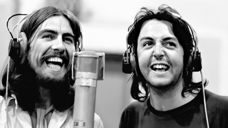 George Harrison and Paul McCartney smiling and wearing studio headphones while recording vocals together at a microphone