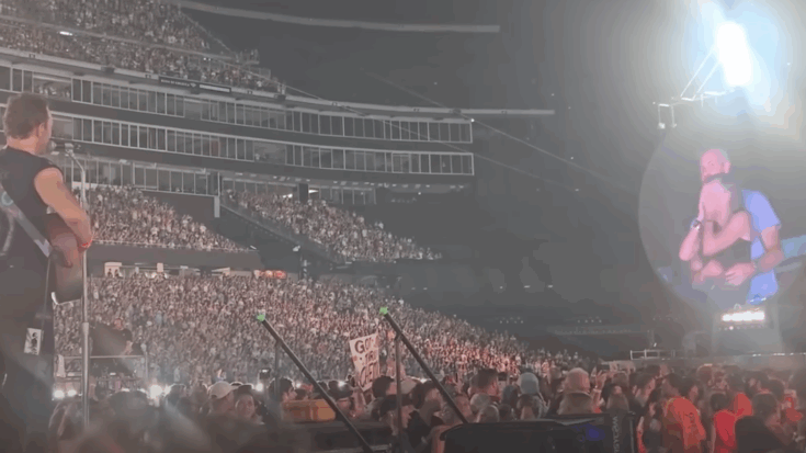 Coldplay plaing on stage with a couple on the bigscreen