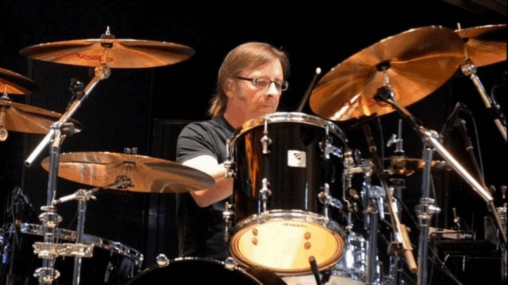 Phil Rudd playing drums on stage surrounded by a full Sonor drum kit during a live performance