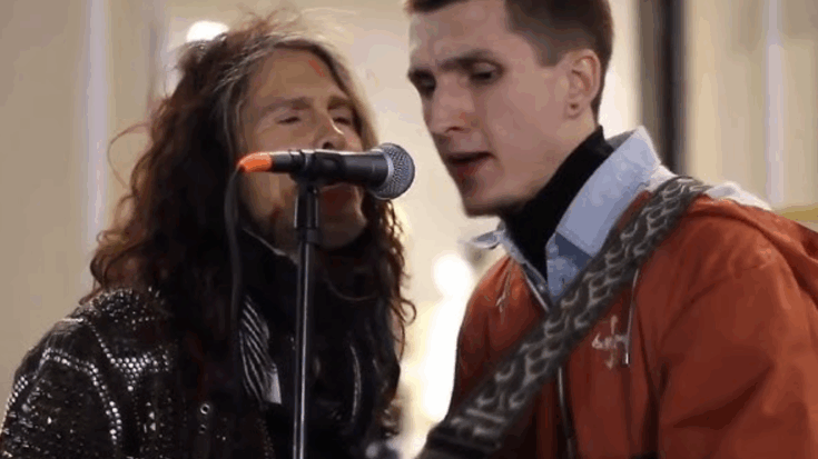 Steven Tyler sings into a microphone alongside a street performer during a spontaneous duet.