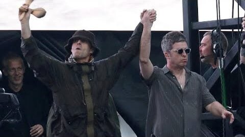Liam and Noel Gallagher hold hands on stage during Oasis' emotional tribute to Ozzy Osbourne at Wembley Stadium.