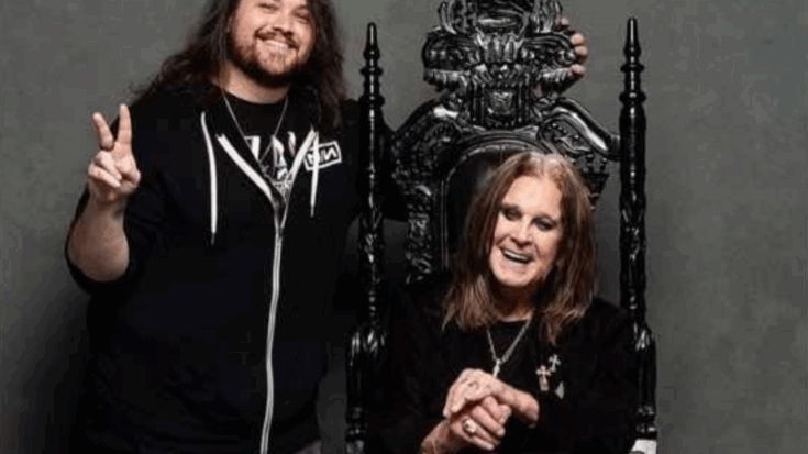 Wolfgang Van Halen standing beside Ozzy Osbourne seated on an ornate black throne, both smiling warmly