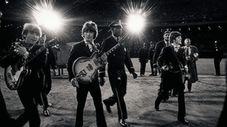 The Beatles walking off stage with guitars after their final paid concert at Candlestick Park in 1966 surrounded by security and staff.
