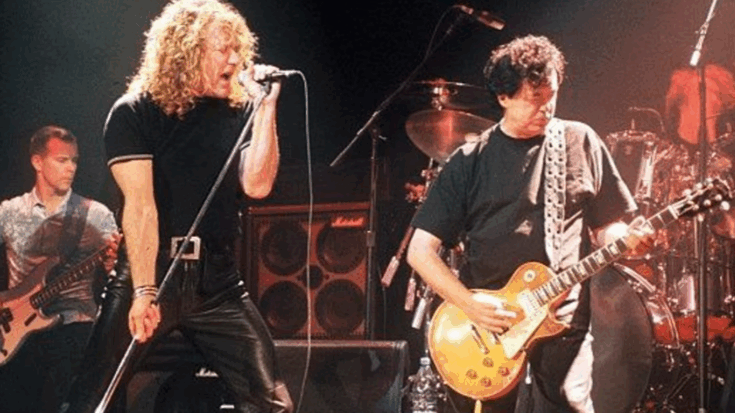 Robert Plant singing on stage beside Jimmy Page playing guitar during a live concert performance.