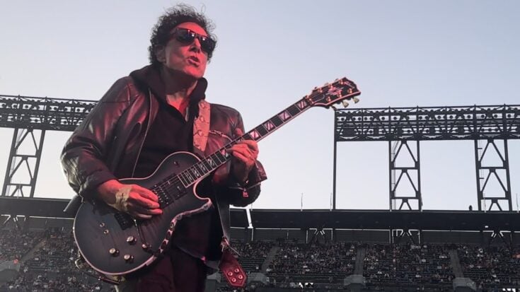 Neal Schon playing a gibson les paul on stage wearing shades