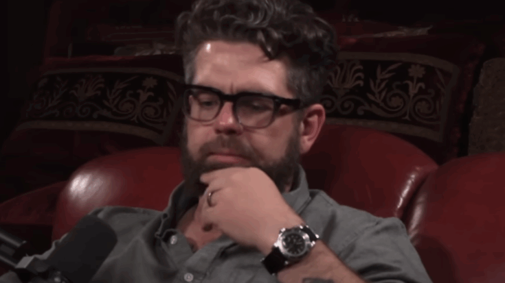 Jack Osbourne rubbing his beard sitting