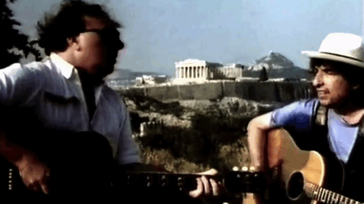 Bob Dylan and Van Morrison performing Crazy Love with acoustic guitars in Athens, Greece in 1989, with the Acropolis in the background.