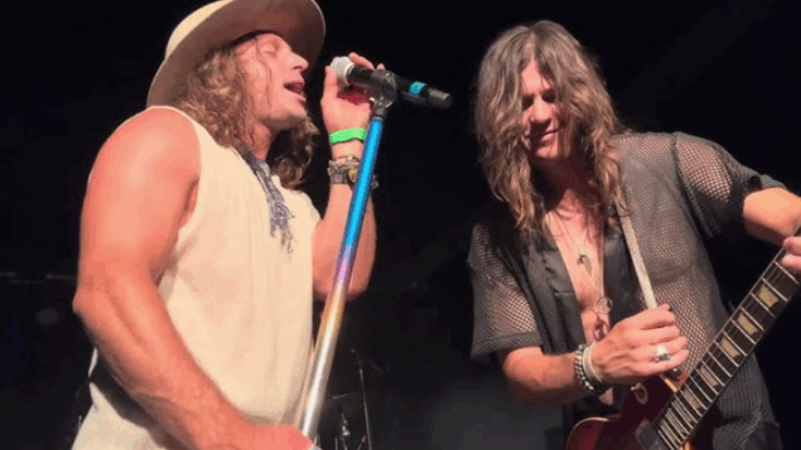 Dirty Honey performing live on stage with the singer at the microphone and guitarist playing electric guitar.