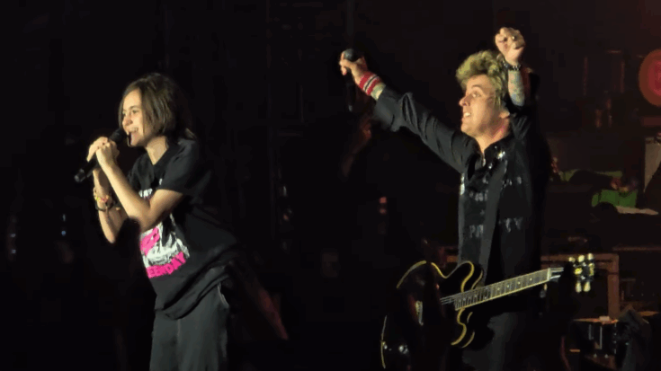 A young fan sings onstage with Green Day’s Billie Joe Armstrong during Riot Fest, after the band invited the child up to help a panicked mother in the crowd.