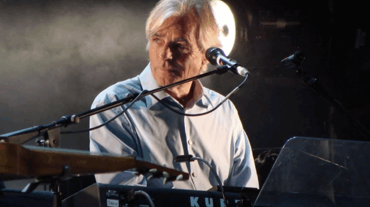 Richard Wright performing on stage, playing keyboards during a live concert