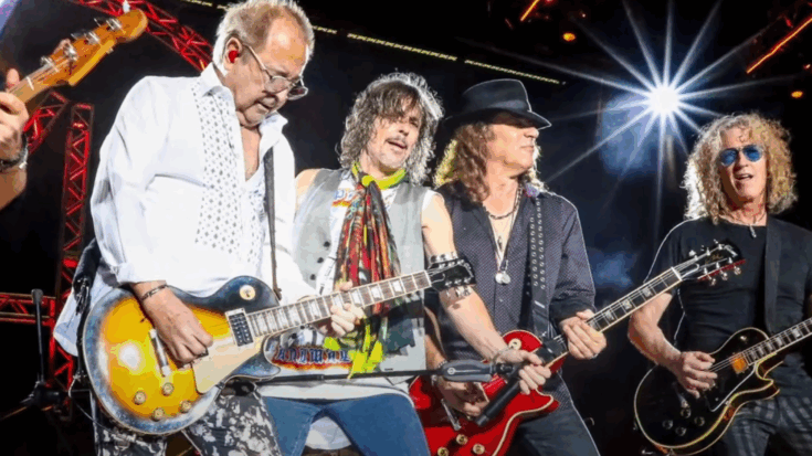 Foreigner performing on stage with Kelly Hansen singing and the band’s guitarists playing under bright concert lights.