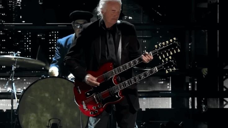 Jimmy Page performing live with a double-neck red guitar during a tribute to Link Wray at the 2023 Rock & Roll Hall of Fame ceremony.