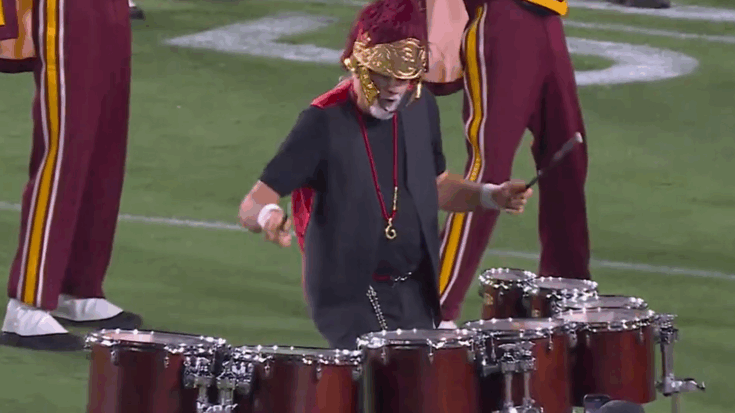 Mick Fleetwood joins the USC Trojan Marching Band at the Coliseum, performing a lively drum solo that energizes the crowd.