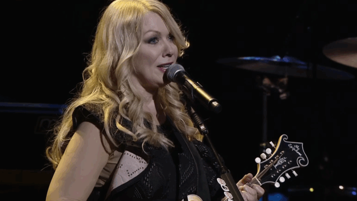 Nancy Wilson performing “These Dreams” live at The Royal Albert Hall in 2016, singing into the microphone while playing a mandolin on stage.