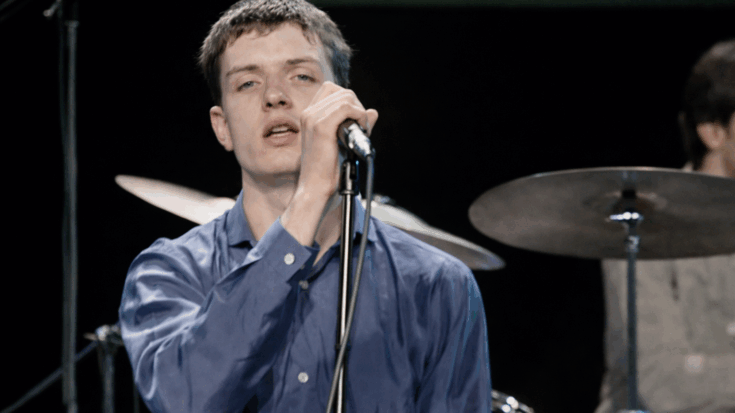 Ian Curtis singin on stage.