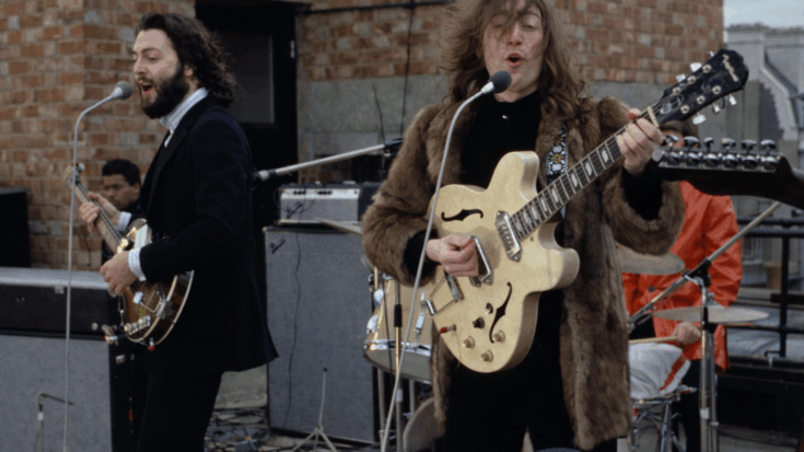 John Lennon and Paul McCartney playing together on a rooftop.