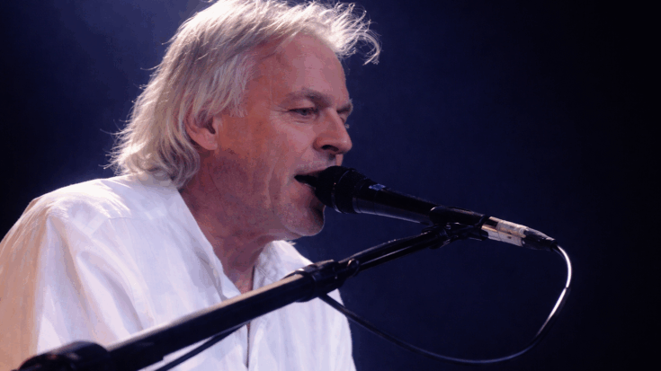 Richard Wright sings at the piano under soft stage lights during a heartfelt live performance.