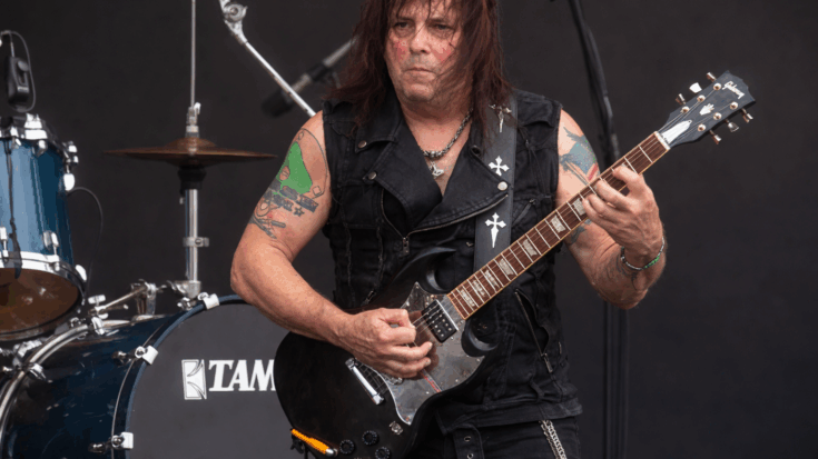 Ross Friedman plays a black Gibson SG onstage while giving an intense live rock performance.