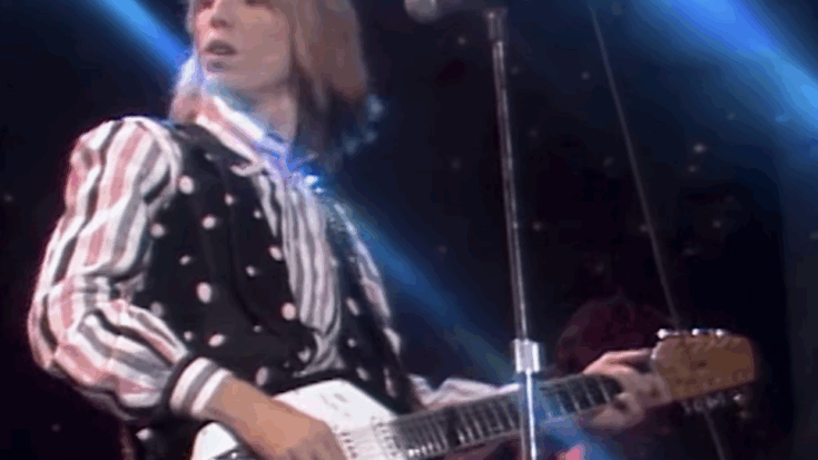 Tom petty playing his vintage guitar performing on stage.