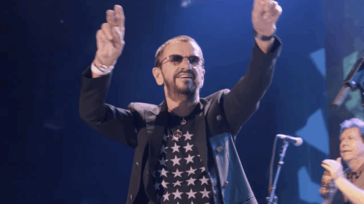 Ringo Starr hyping up the crowd and smiling.
