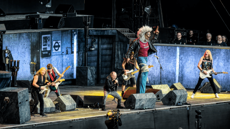 Iron Maiden performs an energetic live show with band members spread across the stage and their mascot Eddie towering at the center.