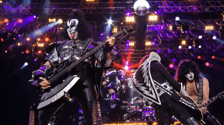 KISS delivers a high-energy performance on stage in full makeup and costumes, surrounded by bright lights and dramatic effects.