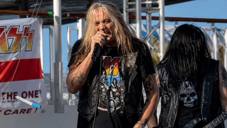 Sebastian Bach sings fiercely into the microphone during an outdoor performance, bringing raw rock energy to the stage.