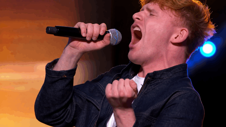 Mickey Callisto is captured mid-performance, passionately belting into a microphone with dramatic stage energy.