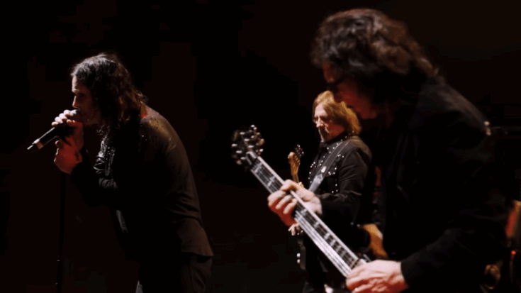 Black Sabbath playing together on stage.