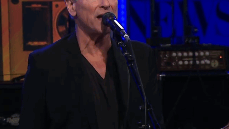 Lindsey buckingham singing and playing guitar on stage with Christie Mcvie