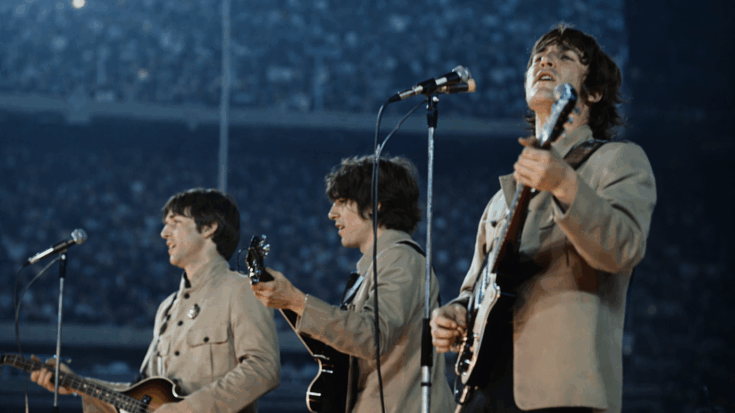 The Beatles perform live onstage in matching suits during their early rock-and-roll era.